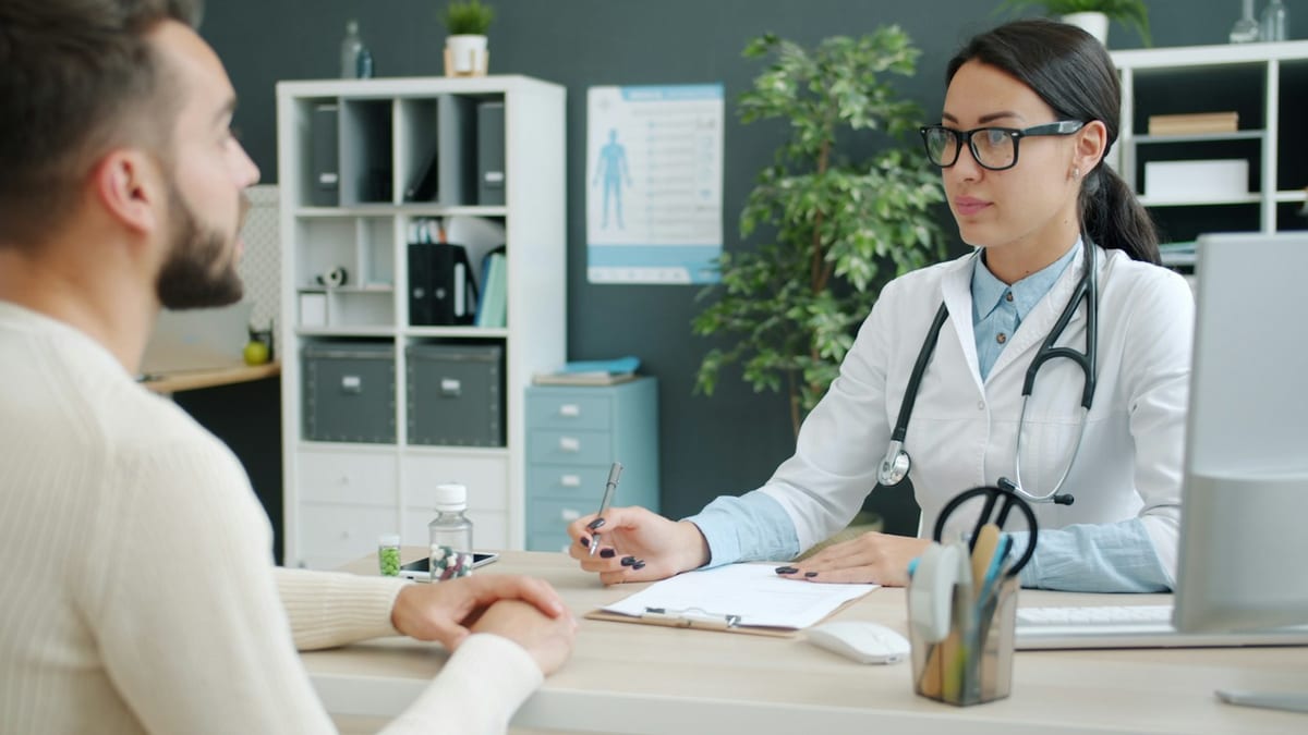 A provider reviewing a chart with a patient in a consultation room